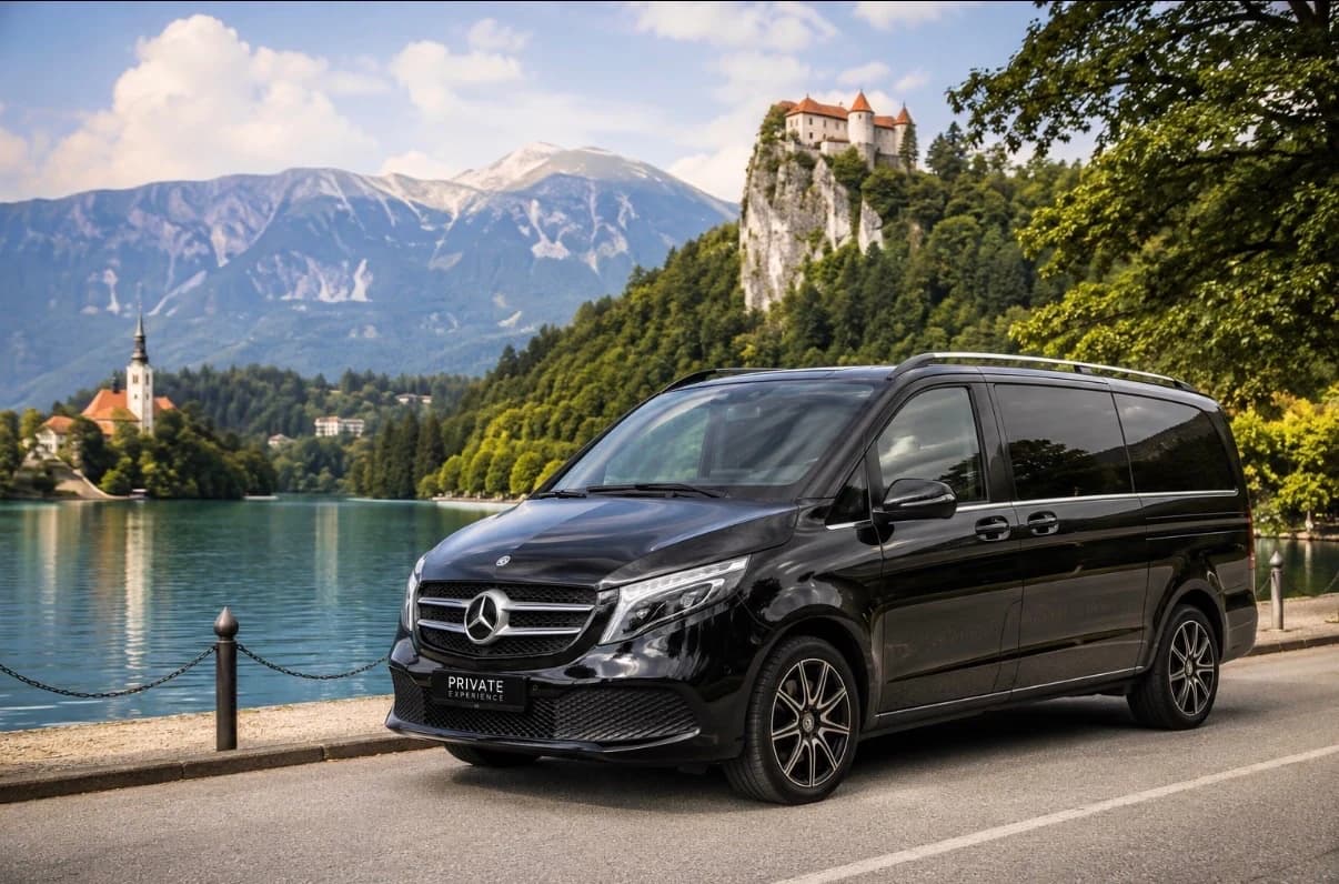 Private driver's car parked beside Lake Bled with Bled Castle in the background